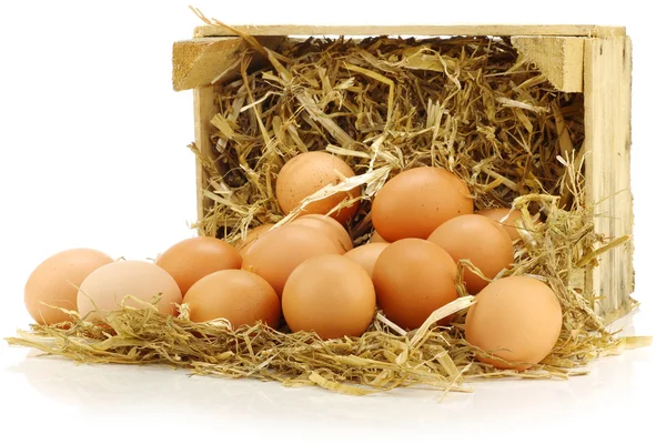 Bunch of fresh brown eggs and some straw in a wooden crate — Stock Photo, Image