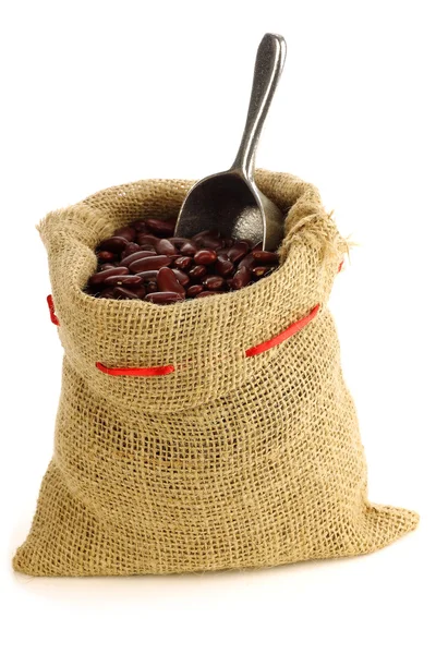 Röda kidneybönor i en säckväv väska och en aluminium scoop — Stockfoto