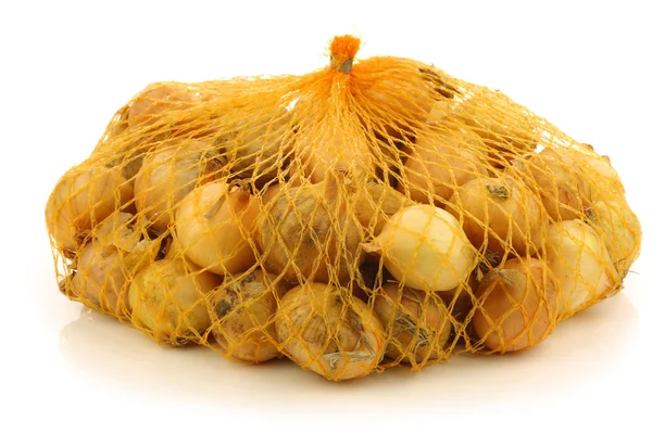 Cebolas de pérola frescas em um saco de plástico amarelo — Fotografia de Stock