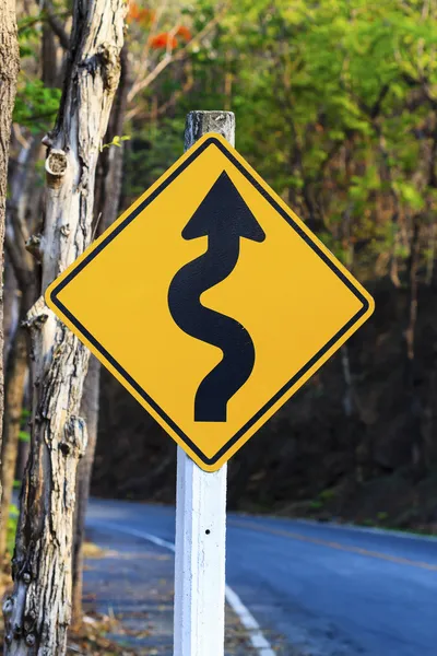 Winding road sign in yellow and black — Stock Photo, Image