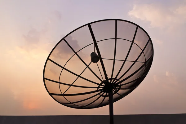 Czarny anteny komunikacji satelitarnej danie nad niebo zachód słońca — Zdjęcie stockowe