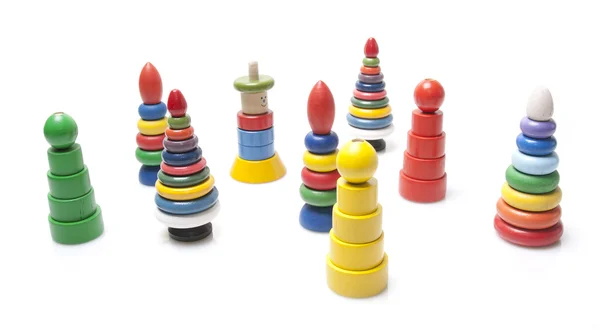 Wiele zabawek kolorowe drewniane piramidy na białym tle — Zdjęcie stockowe