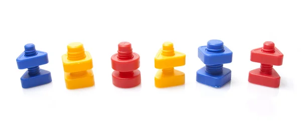 Kolorowe zabawki nakrętki i śruby na białym tle — Zdjęcie stockowe