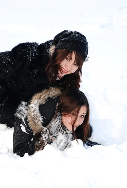 Две сестры играют со снегом — стоковое фото