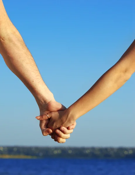 Pareja cogida de la mano en la playa —  Fotos de Stock