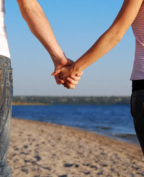 情侣们手牵手在海滩上 — 图库照片