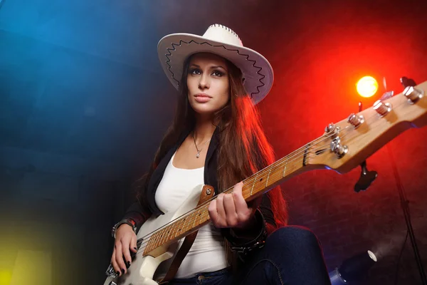 Молодая красивая женщина играет на гитаре на сцене — стоковое фото