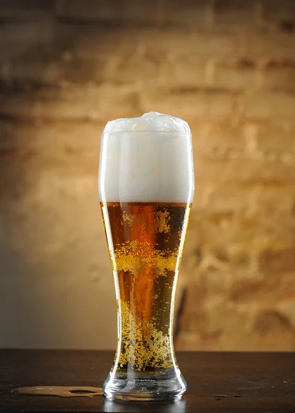 Stock image Beer into glass on a old stone