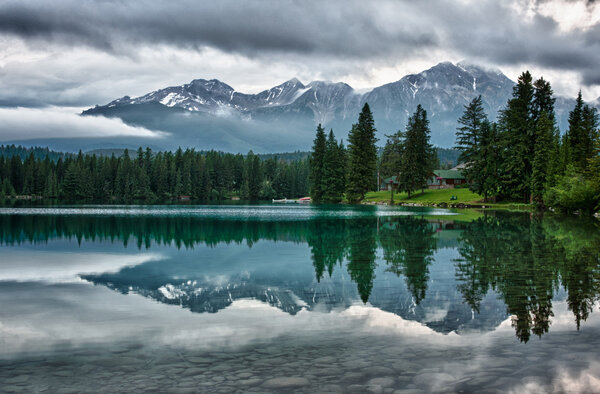 Foggy morning over Canadian Rocky Mountains perfectly mirrors in