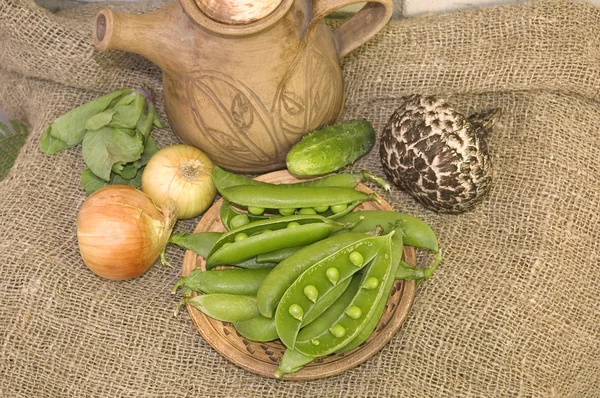 Pods af ærter og grøntsager i det gamle væv - Stock-foto