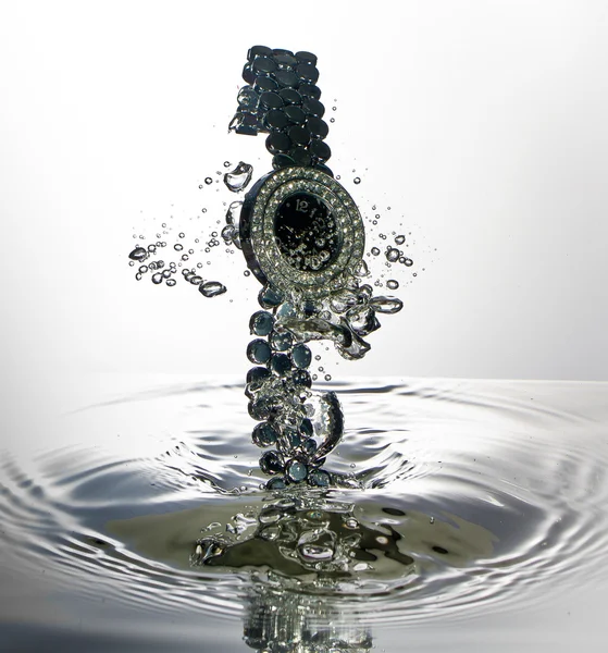 Horloge, horloge, sieraden en juwelen met water splash — Stockfoto
