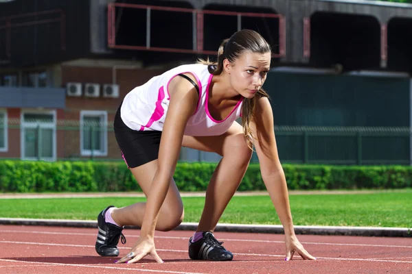 Mladá žena v pozici sprintovat — Stock fotografie