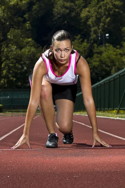 Młoda kobieta w pozycji Sprint — Zdjęcie stockowe