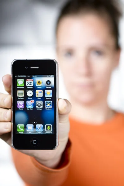 Женщина держит iPhone 4S — стоковое фото