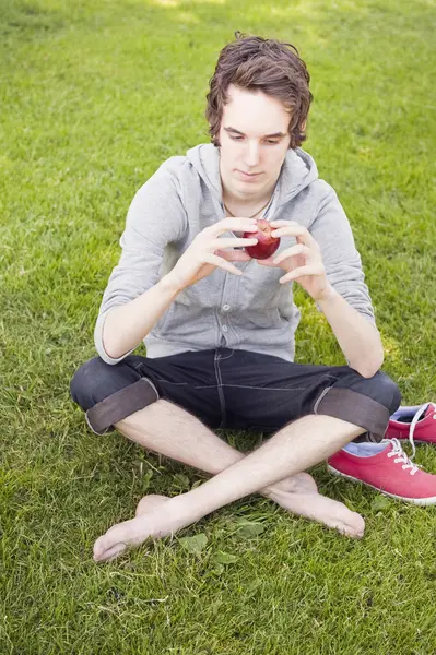Un tânăr care deține un măr — Fotografie, imagine de stoc