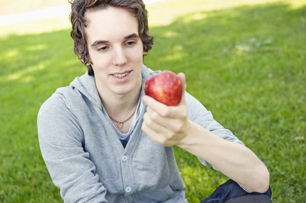 Молодой человек держит яблоко — стоковое фото