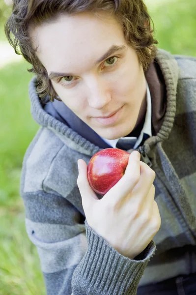 Młody człowiek trzyma jabłko — Zdjęcie stockowe