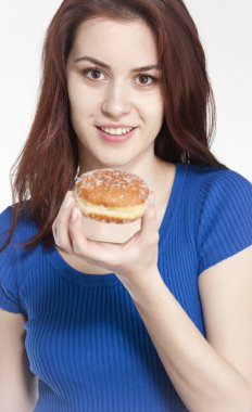 Genç bir kadın elinde donut tutuyor.