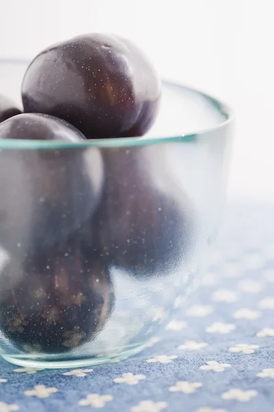 Glass bowl with plums — Stock Photo, Image