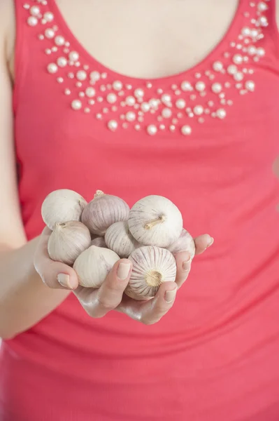 stock image Young woman holding garlic in her hand