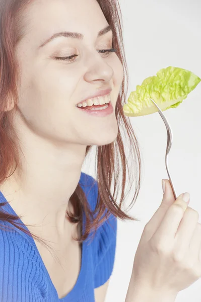Young woman eating lettuce — Stock Photo, Image