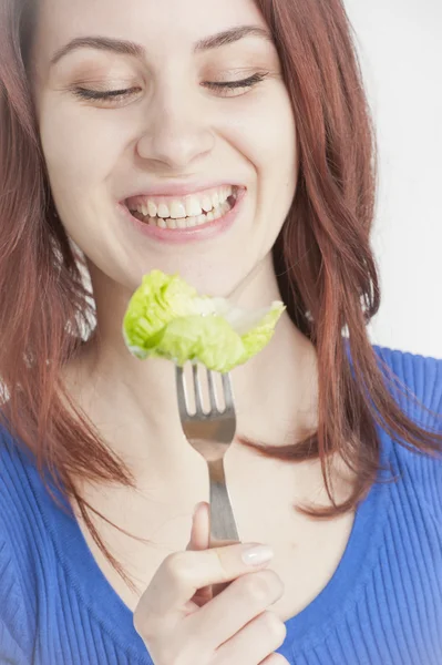 Jovem mulher comendo alface — Fotografia de Stock
