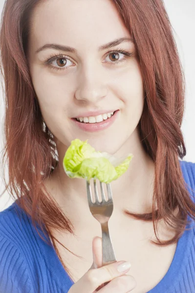 Jovem mulher comendo alface — Fotografia de Stock