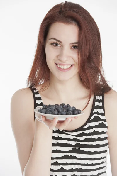 Junge Frau hält einen Teller mit Blaubeeren — Stockfoto