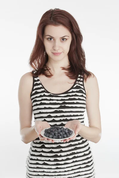 Молодая женщина держит тарелку с черникой — стоковое фото