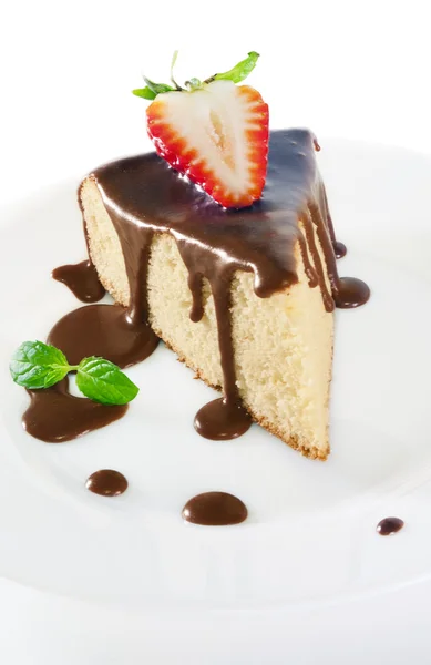 Ein Stück Biskuitteig mit Schokoladensauce auf einem weißen Teller. — Stockfoto