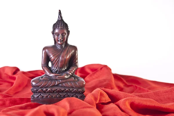 Trä buddha staty på rött tyg — Stockfoto