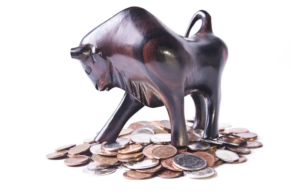 A strong, triumphant bull atop a pile of coins, signifying an op — Stock Photo, Image