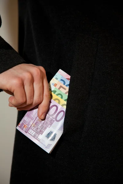 Человек кладет деньги в карман пальто. — стоковое фото