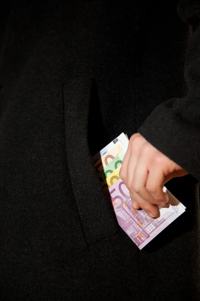 El hombre está poniendo dinero en el bolsillo de su abrigo —  Fotos de Stock