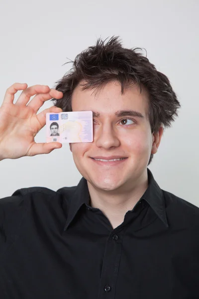 Nuori mies nauraa ajokortillaan tekijänoikeusvapaita kuvapankkikuvia