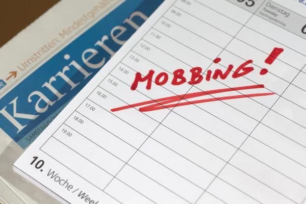 Das Schreiben von Mobbing auf einem Kalender Stockbild