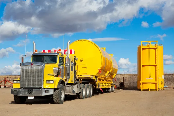 Transport jaune avec des réservoirs de champ pétrolifère — Photo