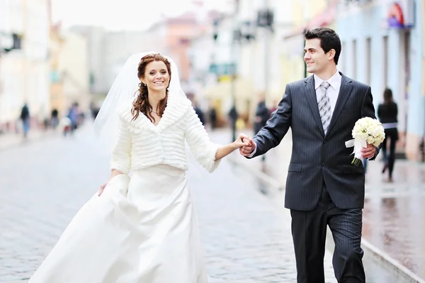Bride and groom walking together hand in hand — Stock Photo, Image