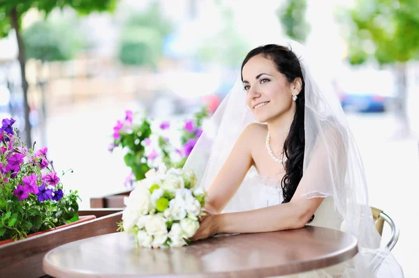 Felice giovane sposa tenendo bouquet da sposa — Foto Stock