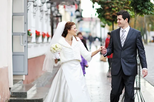 Young happy bride and groom having fun in an old town — Stock Photo, Image