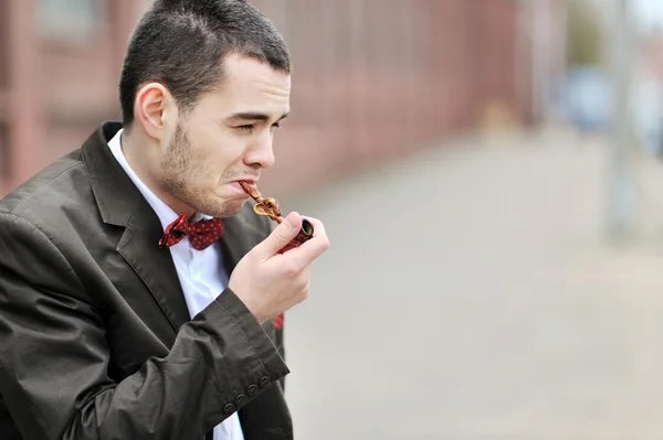 Junger Mann raucht Pfeife — Stockfoto