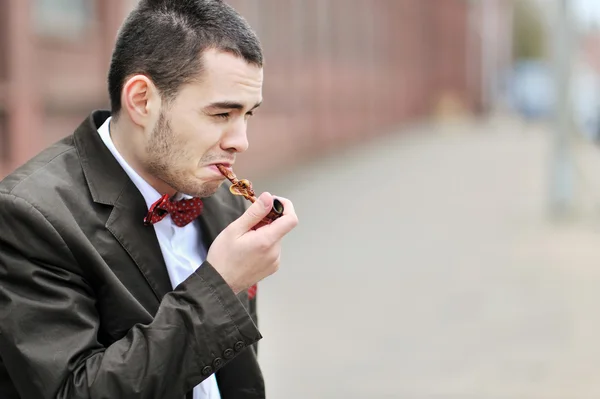 stock image Young man smoking a pipe