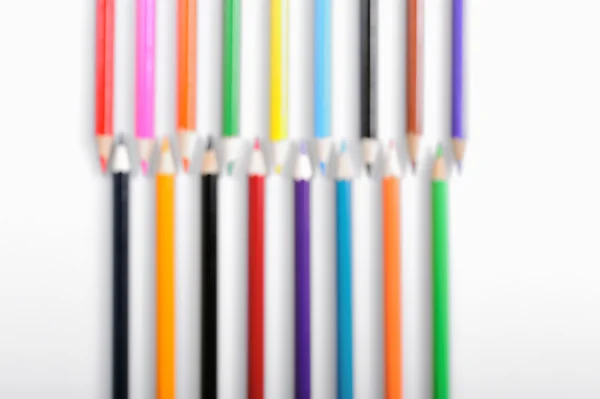 Färgpennor i oskärpa på vit bakgrund — Stockfoto