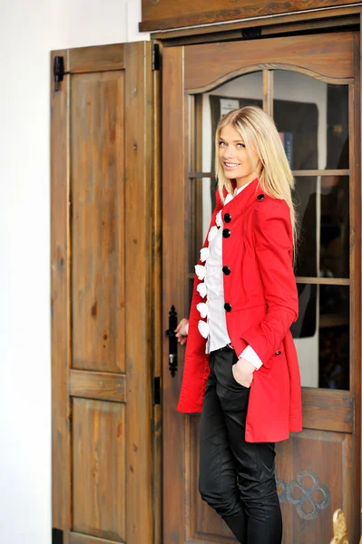 Jovem senhora em vestido vermelho abrindo uma porta — Fotografia de Stock