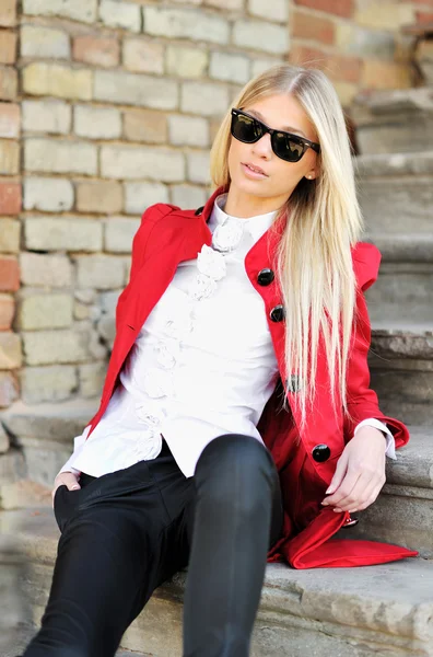 Mujer joven en traje rojo y gafas de sol retrato al aire libre —  Fotos de Stock