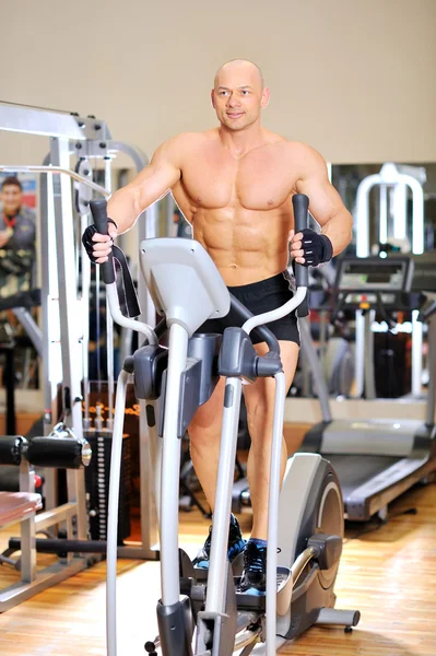 Stationary bicycles fitness man in a gym sport club — Stock Photo, Image