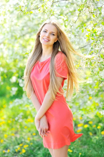 Porträt einer schönen Frau in einem blühenden Baum im Frühling — Stockfoto