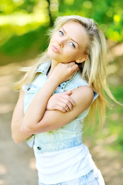 Krásná mladá dívka stojící v parku — Stock fotografie