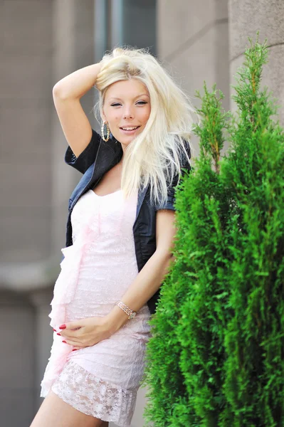Pretty pregnant girl touching her tummy and posing outdoors — Stock Photo, Image