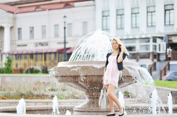 Schöne junge Frau posiert am Brunnen in der Altstadt — Stockfoto
